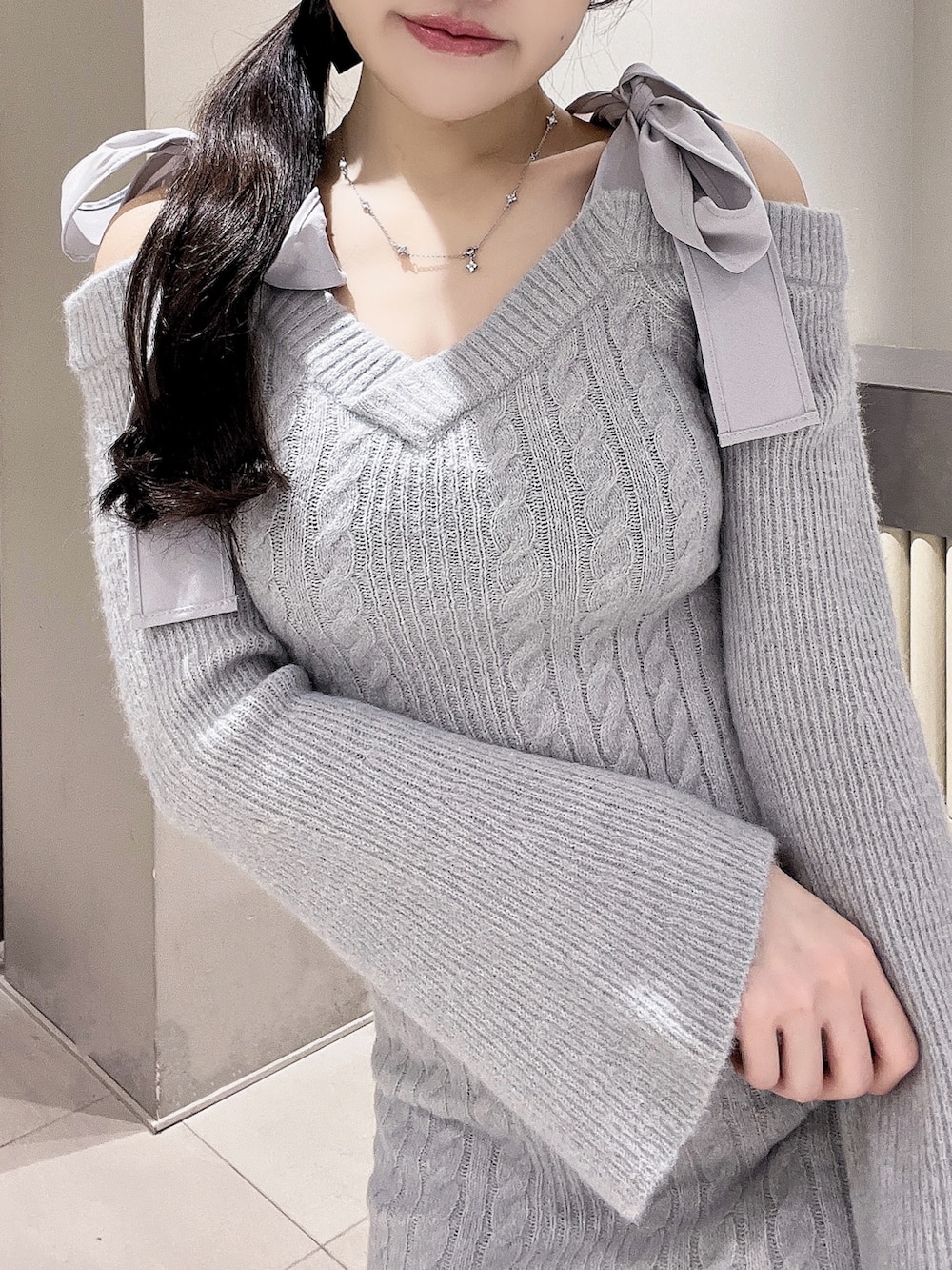 グレー系のワンピース、ホワイト系のブーツ、ブラック系のバレッタ/ヘアクリップを着用したレディースの冬コーディネートの4枚目の写真