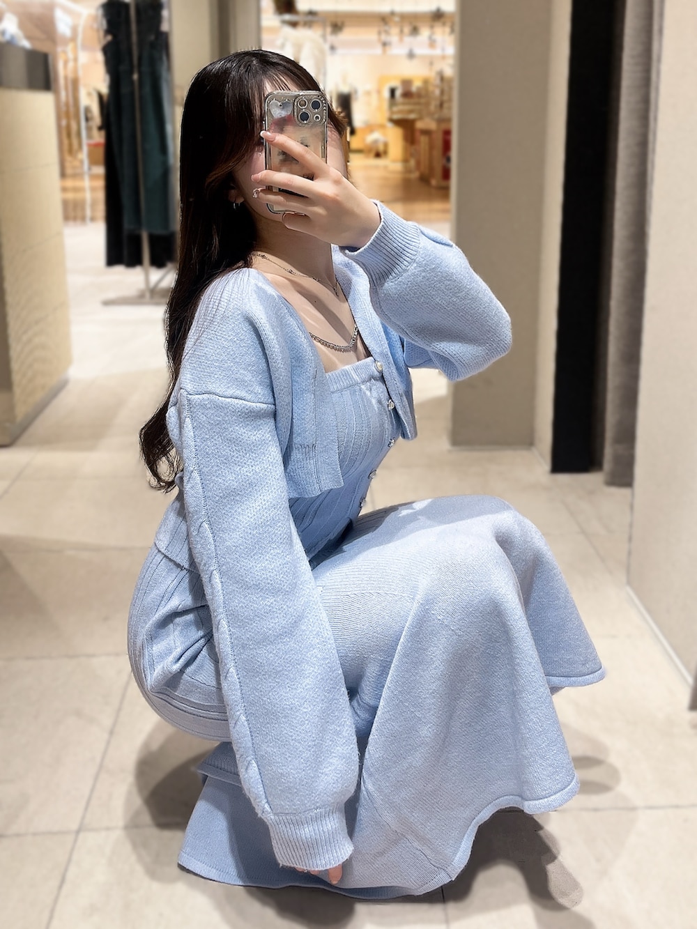 ブルー系のニット/セーター、ブルー系のスカート、ブラック系のブーツを着用したレディースの冬コーディネートの5枚目の写真