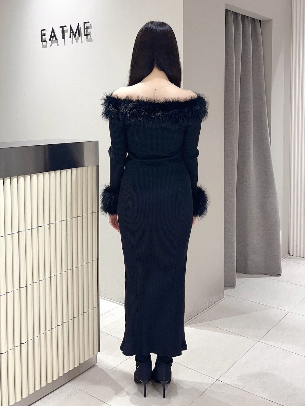 ブラック系のワンピース、ブラック系のブーツを着用したレディースの秋コーディネートの4枚目の写真