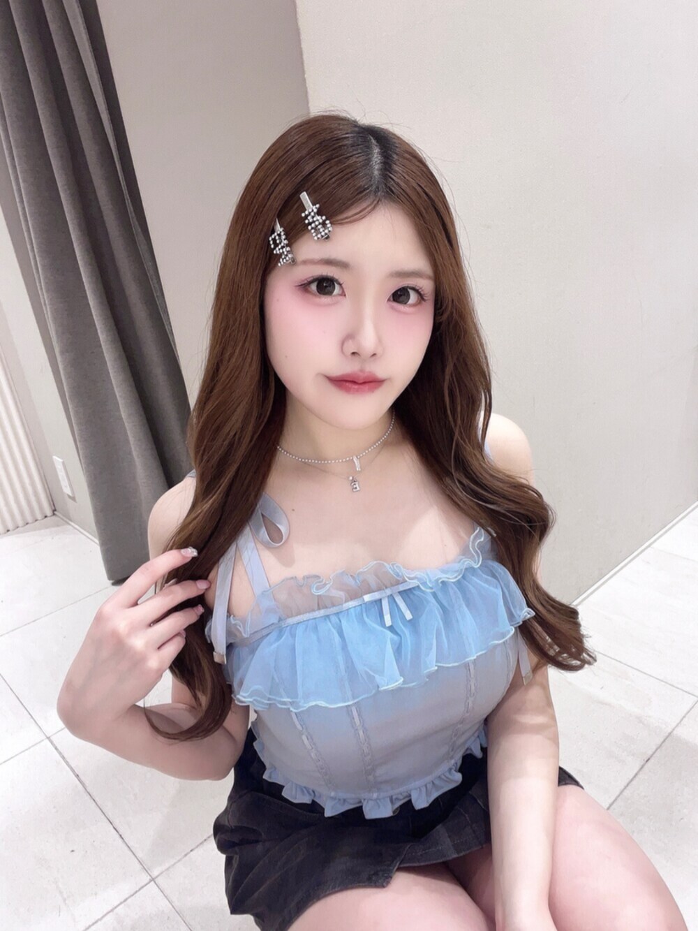 ブルー系のキャミソール、ブラック系のデニムスカート、ブラック系のサンダルを着用したレディースの春コーディネートの2枚目の写真