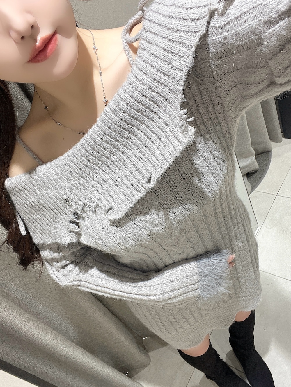 グレー系のワンピース、ブラック系のブーツ、ブラック系のバレッタ/ヘアクリップを着用したレディースの秋コーディネートの4枚目の写真