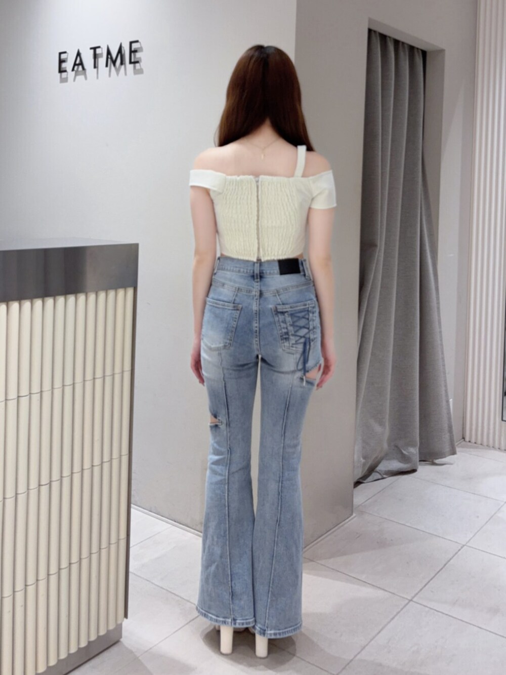 ホワイト系のサンダル、ホワイト系のショルダーバッグ、ブルー系のデニムパンツを着用したレディースの夏コーディネートの4枚目の写真