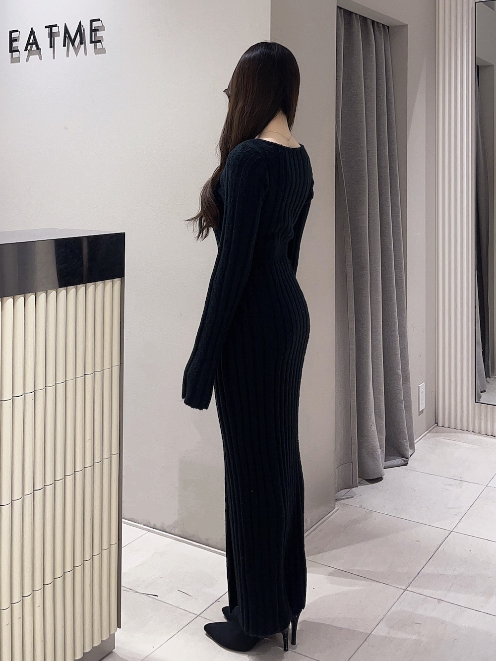 ブラック系のワンピース、ブラック系のブーツを着用したレディースの冬コーディネートの3枚目の写真