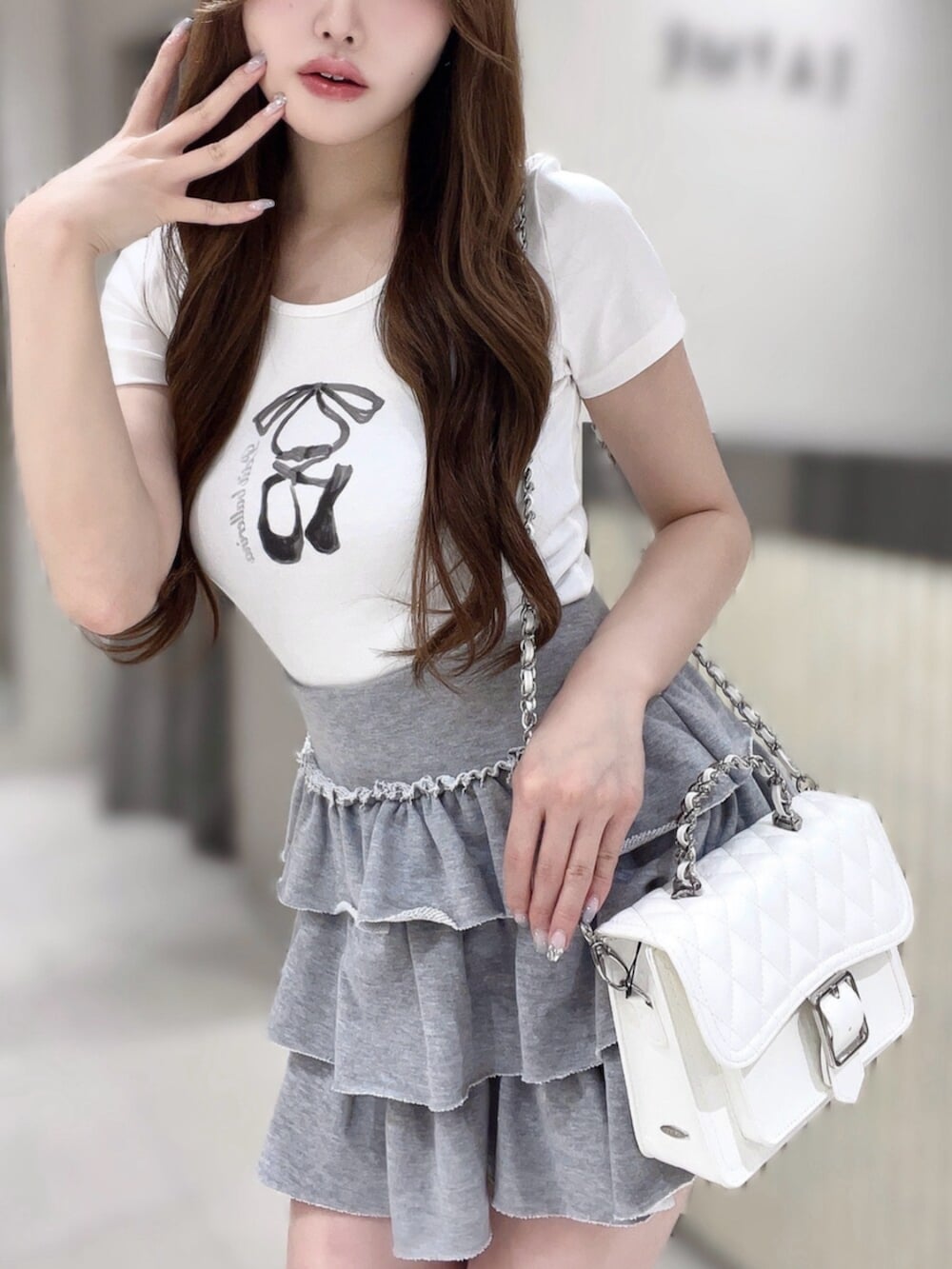 グレー系のスカート、ホワイト系のTシャツ/カットソー、ホワイト系のショルダーバッグを着用したレディースの夏コーディネートの5枚目の写真
