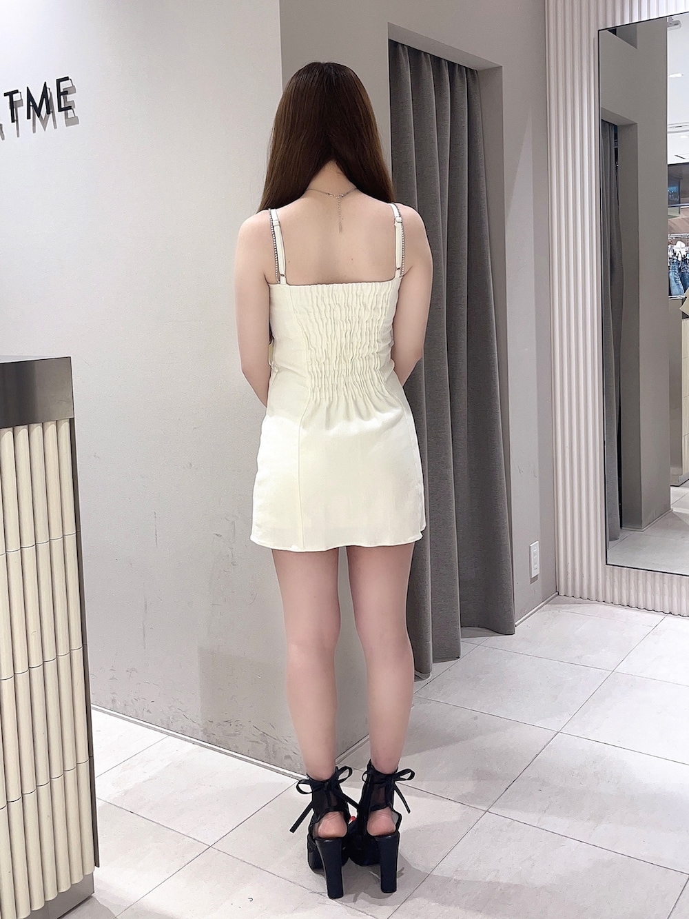 ホワイト系のワンピース、ブラック系のサンダルを着用したレディースの夏コーディネートの3枚目の写真