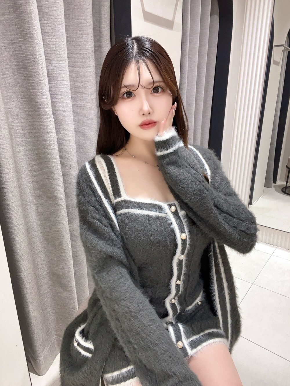 グレー系のワンピース、ブラック系のブーツを着用したレディースの冬コーディネートの5枚目の写真