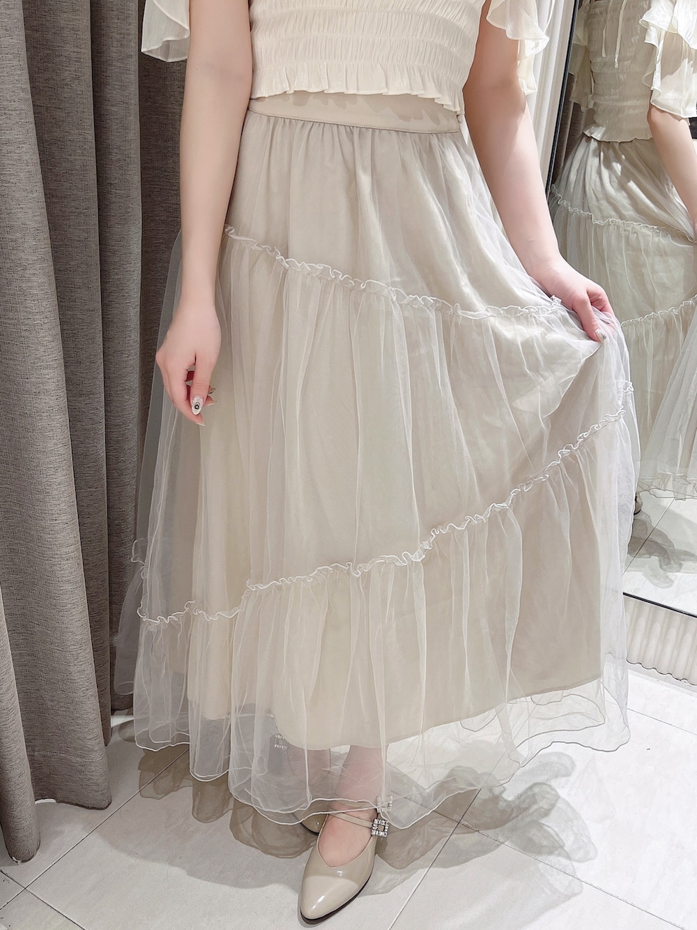 ホワイト系のTシャツ/カットソー、ベージュ系のスカート、ベージュ系のパンプスを着用したレディースの夏コーディネートの6枚目の写真