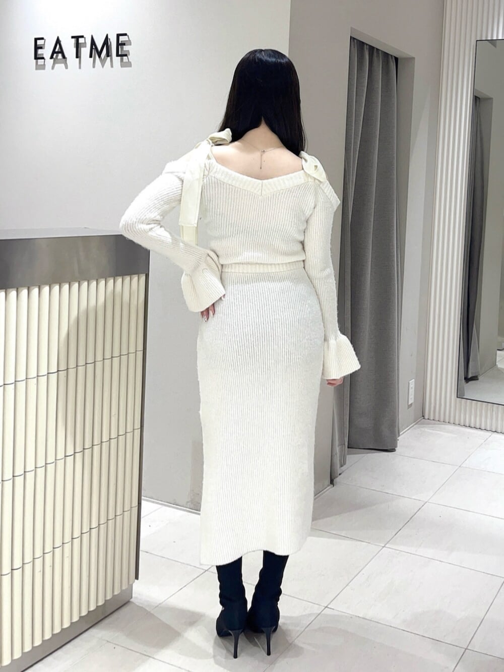 ホワイト系のワンピース、ブラック系のブーツを着用したレディースの冬コーディネートの4枚目の写真