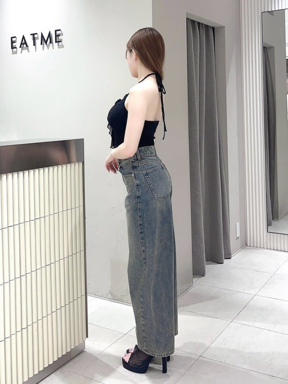 ブラック系のサンダル、ブラック系のキャミソール、ブルー系のデニムパンツを着用したレディースの夏コーディネートの2枚目の写真