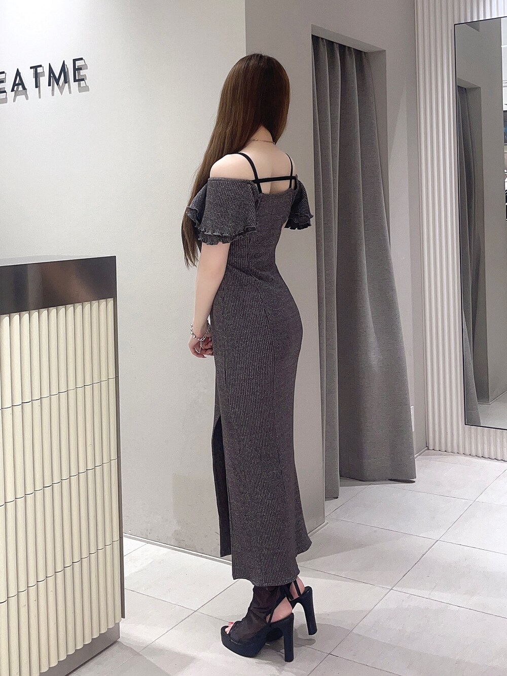 ブラック系のサンダル、グレー系のワンピースを着用したレディースの夏コーディネートの3枚目の写真