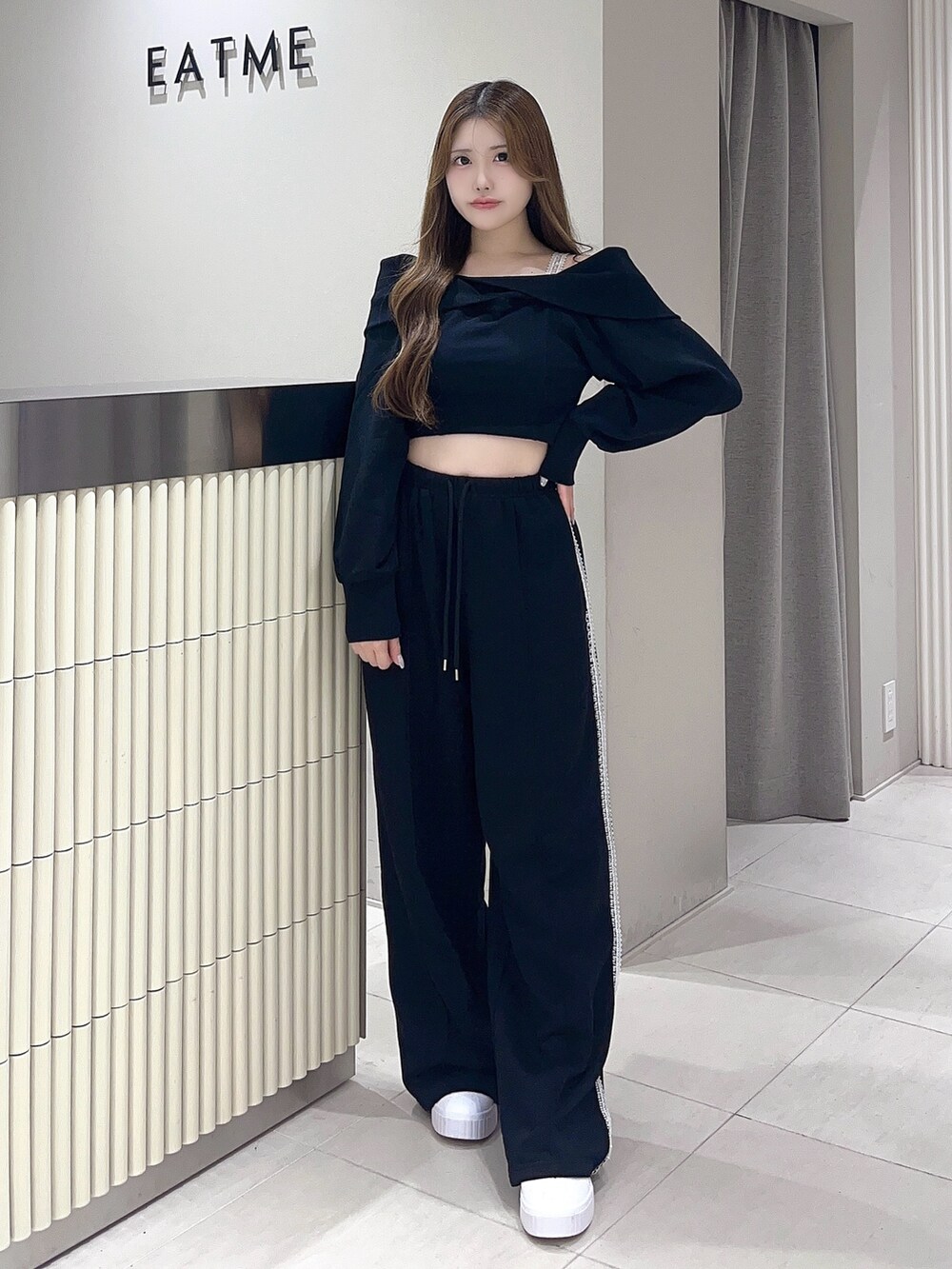 ブラック系のTシャツ/カットソー、ブラック系のスウェットパンツ、ホワイト系のスニーカーを着用したレディースの夏コーディネートの2枚目の写真