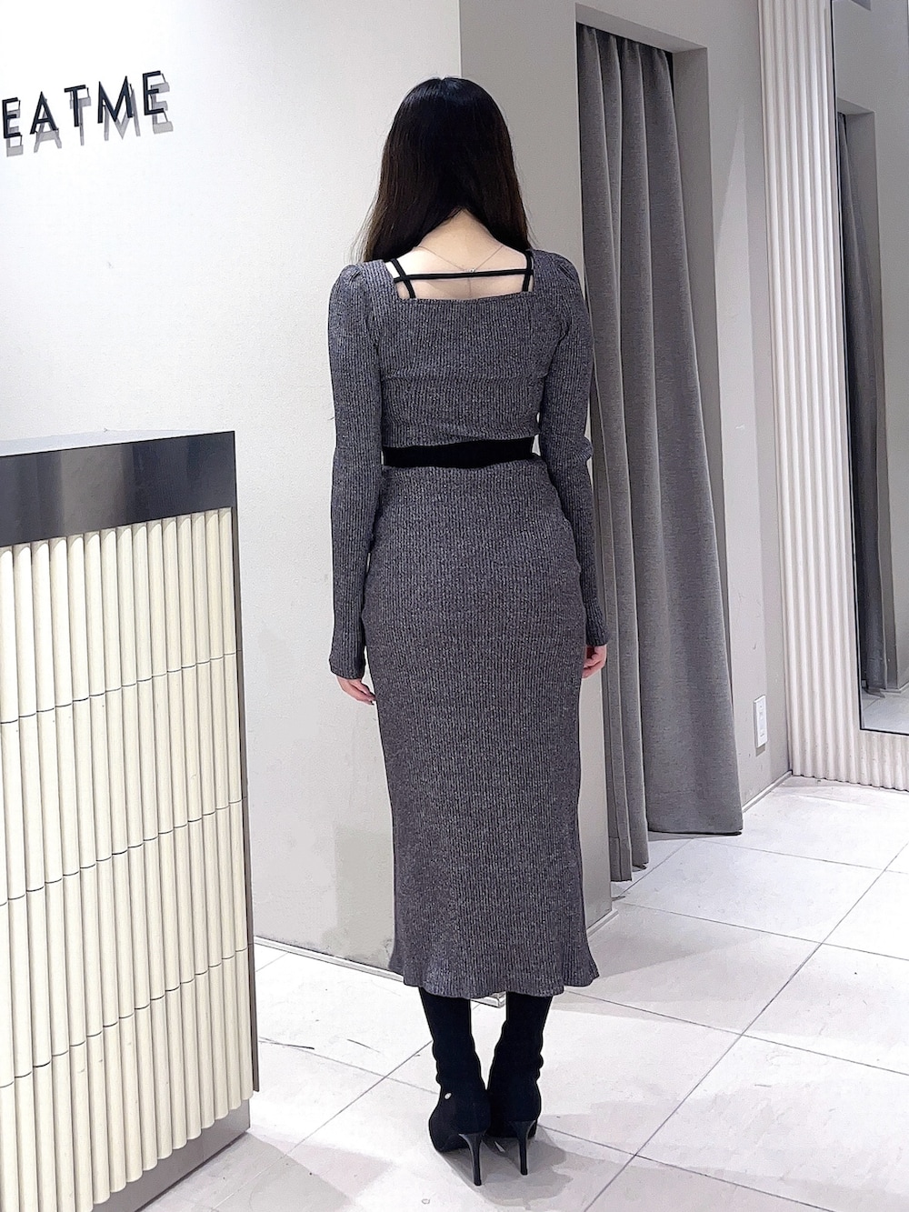 グレー系のTシャツ/カットソー、グレー系のスカート、ブラック系のブーツを着用したレディースの冬コーディネートの3枚目の写真