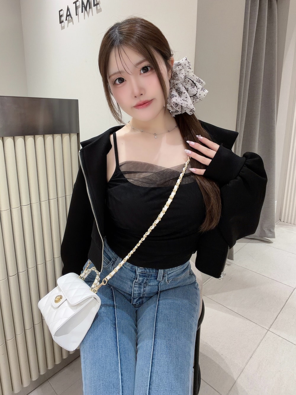 ブラック系のTシャツ/カットソー、ブラック系のパーカー、ホワイト系のハンドバッグを着用したレディースの春コーディネートの4枚目の写真