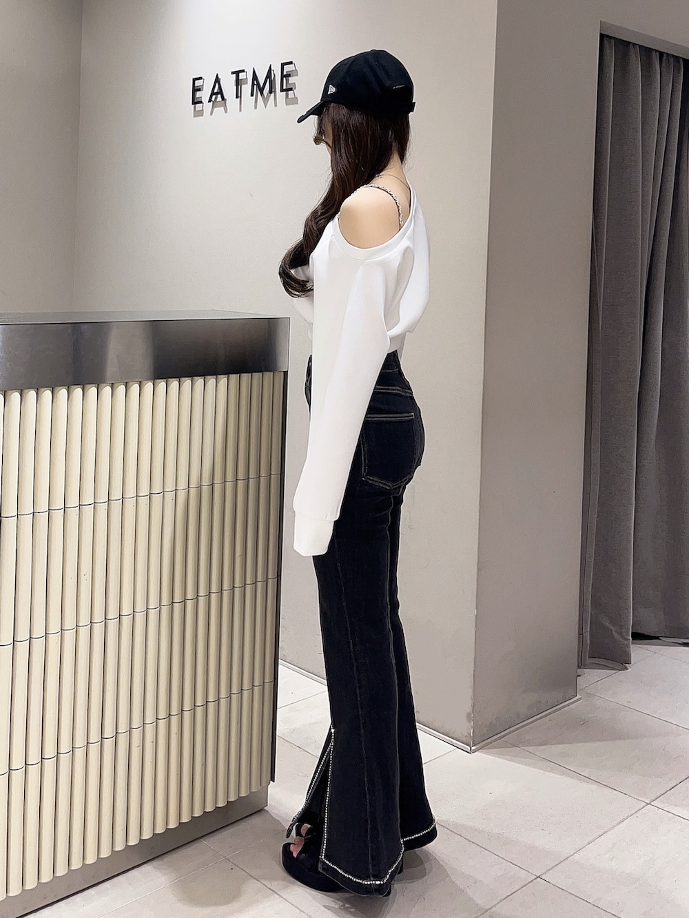 ホワイト系のスウェット、ブラック系のデニムパンツ、ブラック系のブーツを着用したレディースの春コーディネートの2枚目の写真