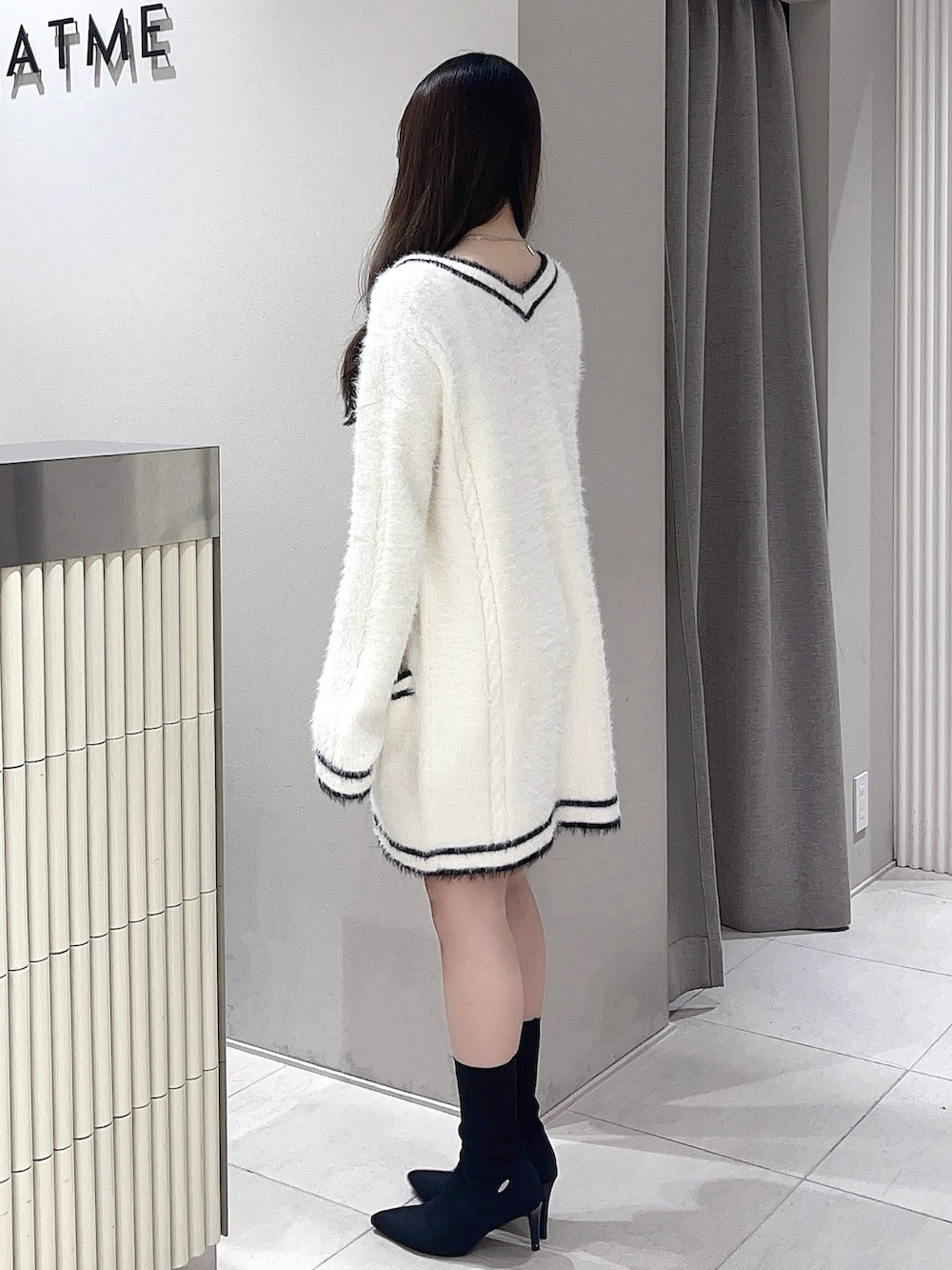 ホワイト系のワンピース、ブラック系のブーツを着用したレディースの冬コーディネートの2枚目の写真