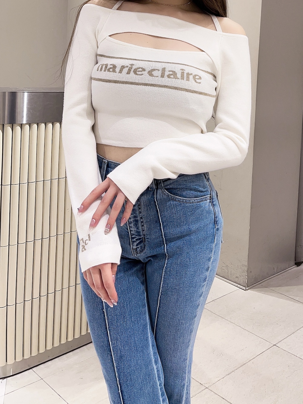 ホワイト系のニット/セーター、ブルー系のデニムパンツ、ホワイト系のブーツを着用したレディースの春コーディネートの4枚目の写真