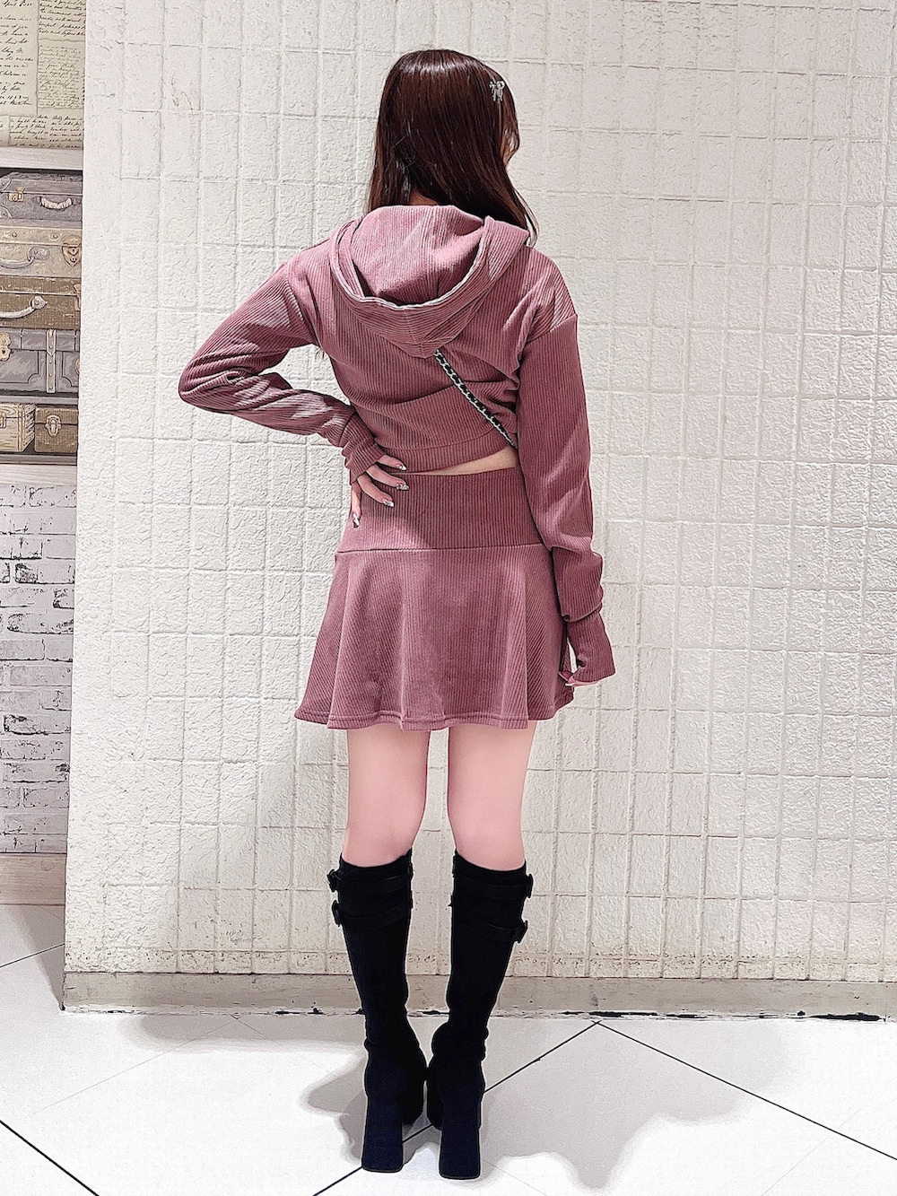 ピンク系のパーカー、ピンク系のスカート、ブラック系のハンドバッグを着用したレディースの秋コーディネートの4枚目の写真