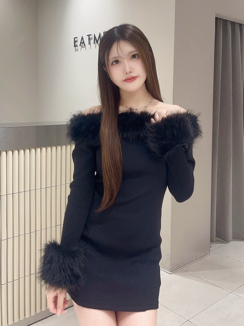 ブラック系のワンピース、ブラック系のブーツを着用したレディースの秋コーディネートの5枚目の写真