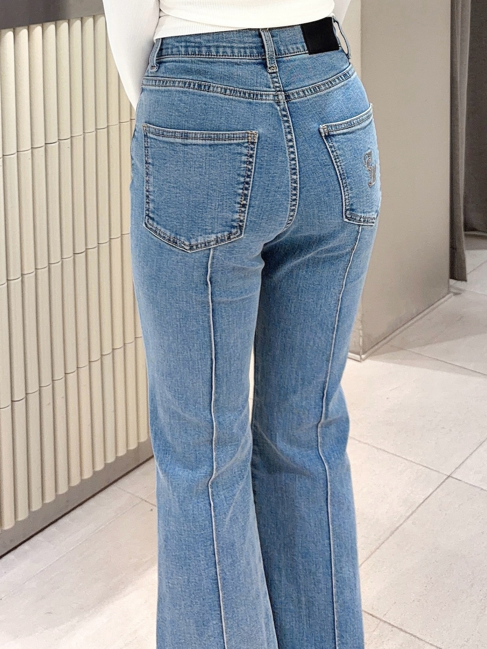 ホワイト系のTシャツ/カットソー、ブルー系のデニムパンツ、ホワイト系のブーツを着用したレディースの春コーディネートの4枚目の写真