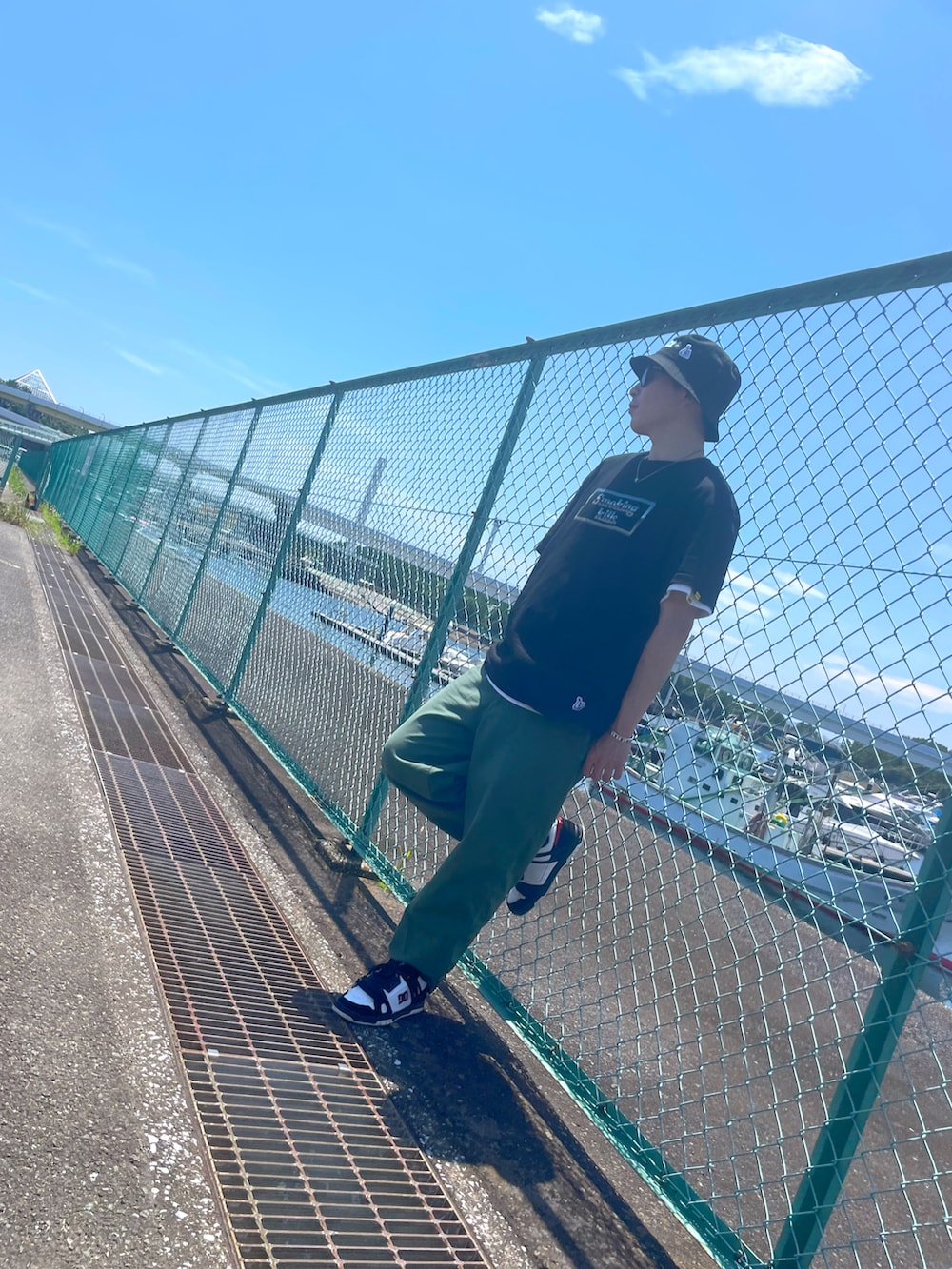 グリーン系のその他パンツ、ブラック系のTシャツ/カットソー、ブラック系のスニーカーを着用したメンズの夏コーディネートの2枚目の写真