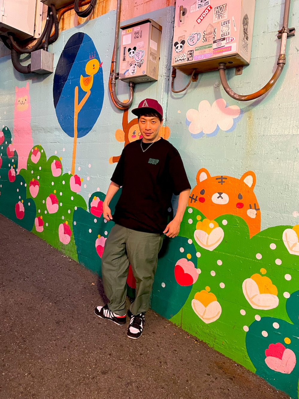 グリーン系のその他パンツ、ブラック系のTシャツ/カットソー、ブラック系のスニーカーを着用したメンズの夏コーディネートの2枚目の写真