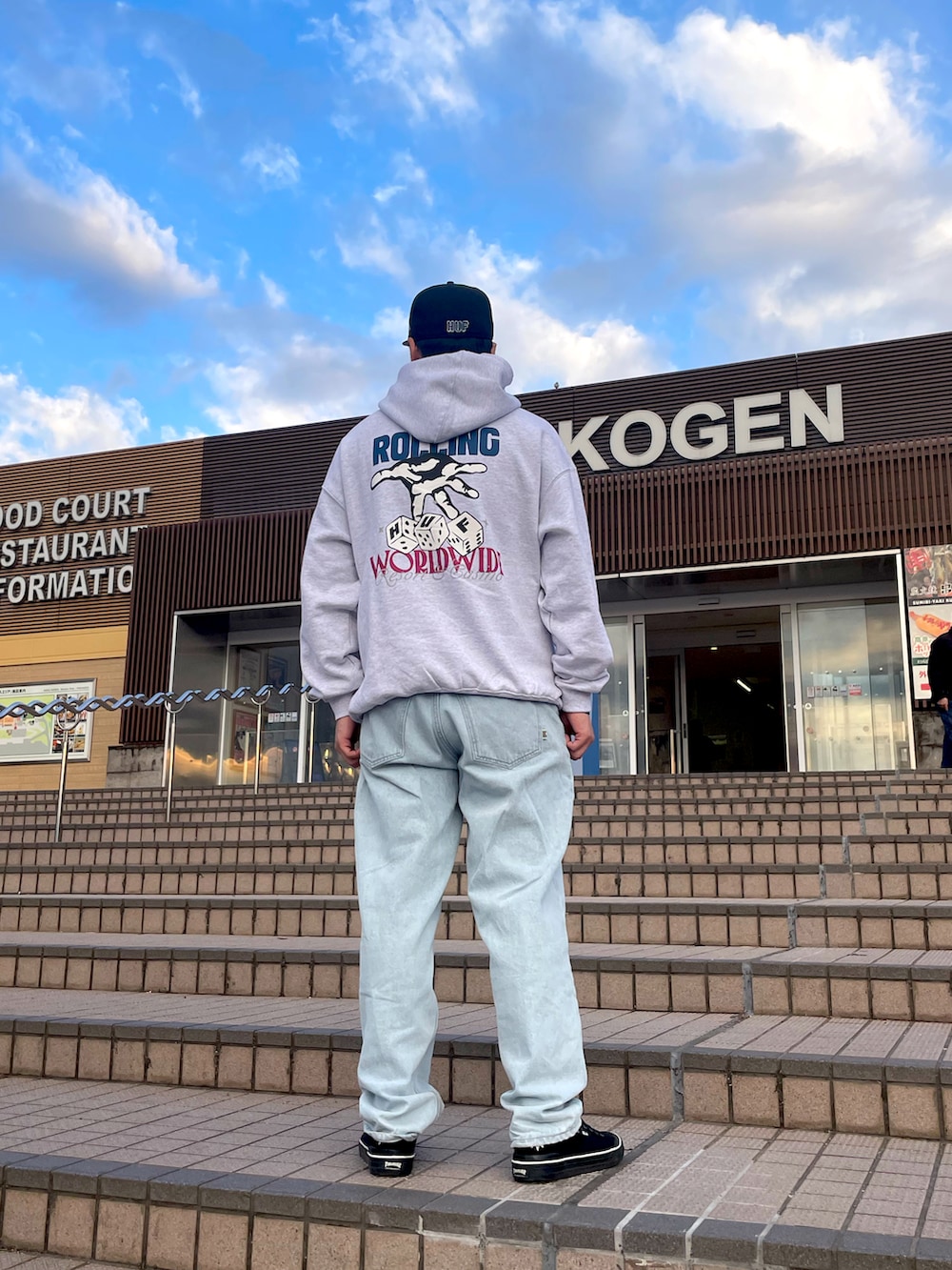 ブラック系のパーカー、ブルー系のデニムパンツ、ブラック系のスニーカーを着用したメンズの冬コーディネートの2枚目の写真