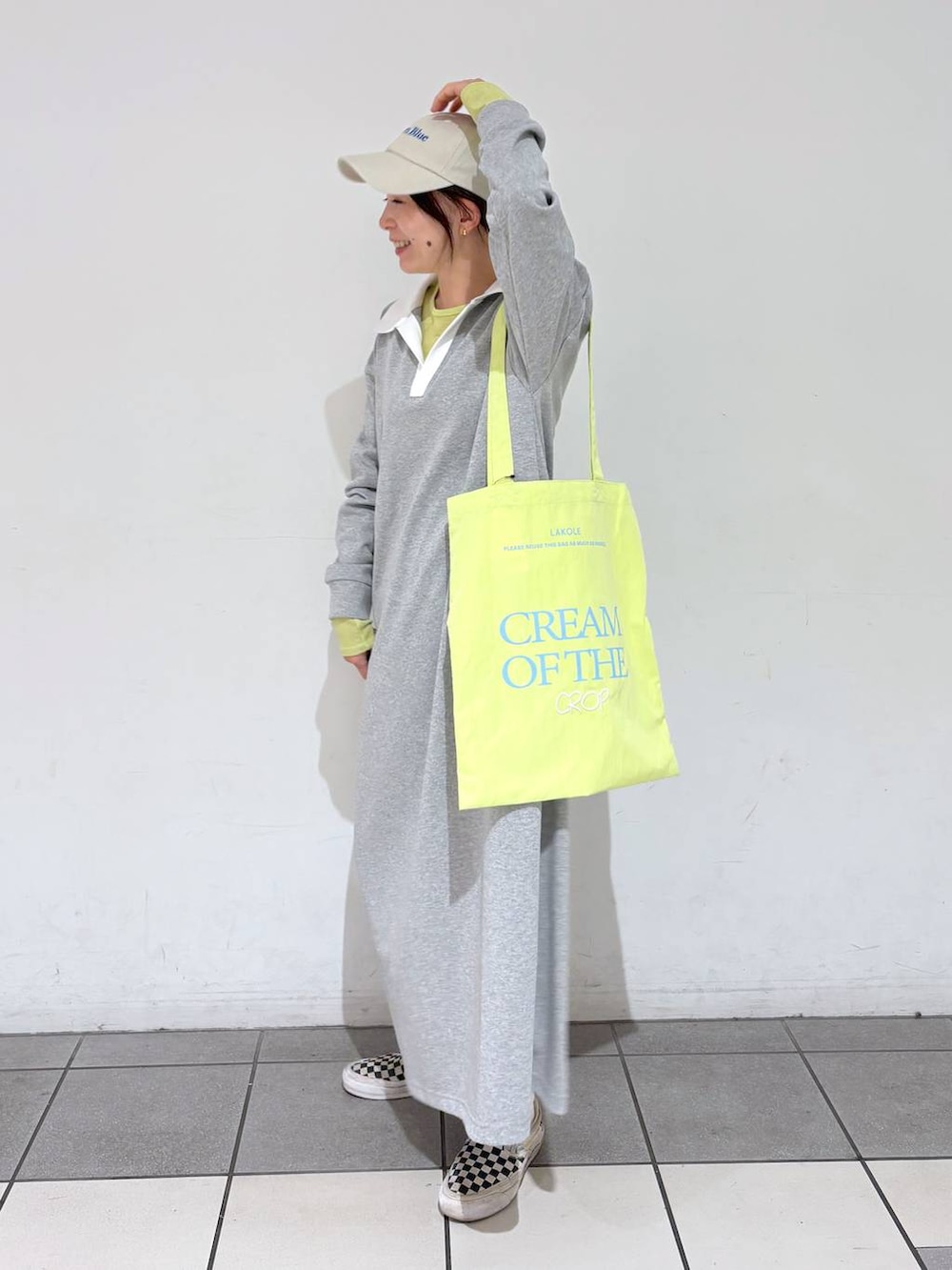 グリーン系のトートバッグ、グレー系のワンピース、ベージュ系のキャップを着用したレディースの冬コーディネートの3枚目の写真