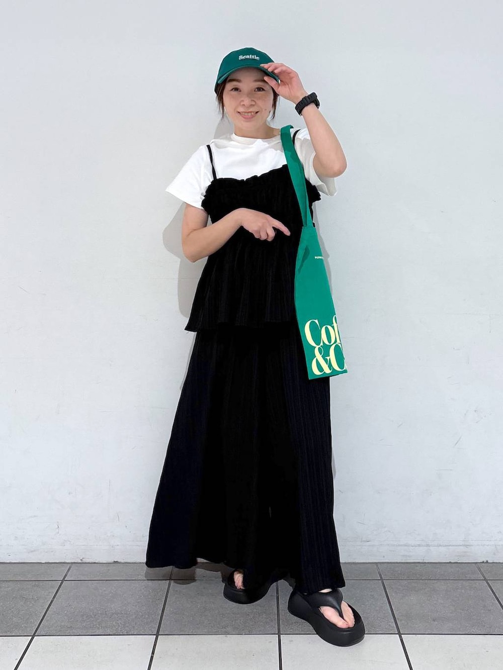 グリーン系のトートバッグ、ブラック系のサンダル、ブラック系のその他パンツを着用したレディースの春コーディネートの3枚目の写真