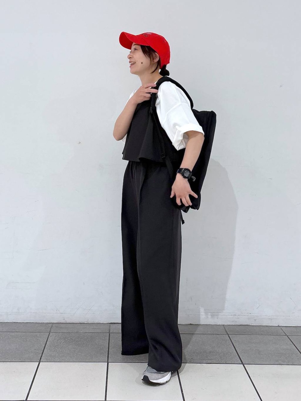 ブラック系のバックパック/リュック、グレー系のサロペット/オーバーオール、ホワイト系のTシャツ/カットソーを着用したレディースの春コーディネートの4枚目の写真