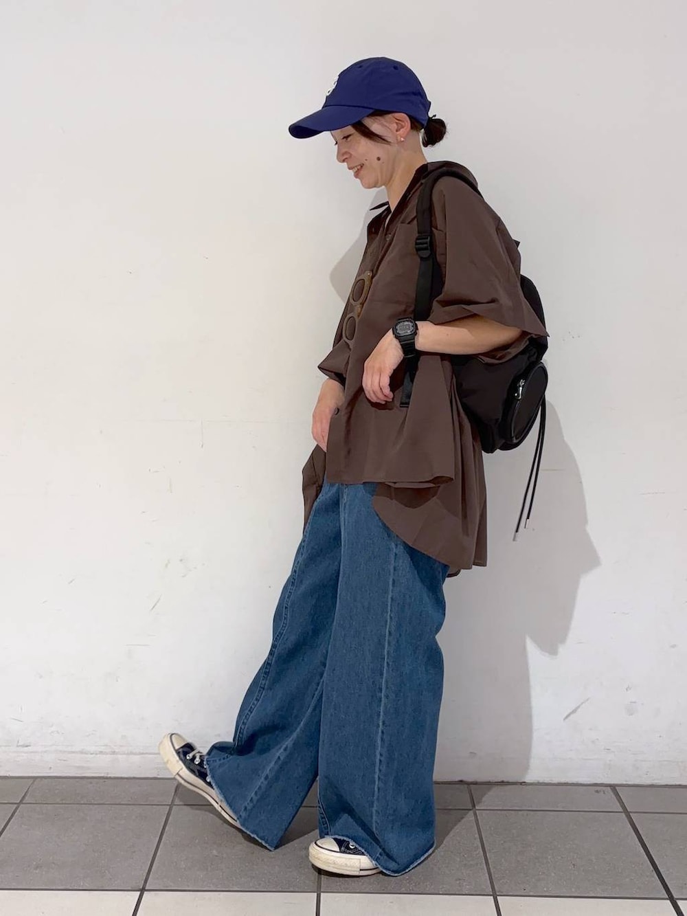 ブルー系のデニムパンツ、ホワイト系のキャミソール、ブラウン系のシャツ/ブラウスを着用したレディースの夏コーディネートの3枚目の写真