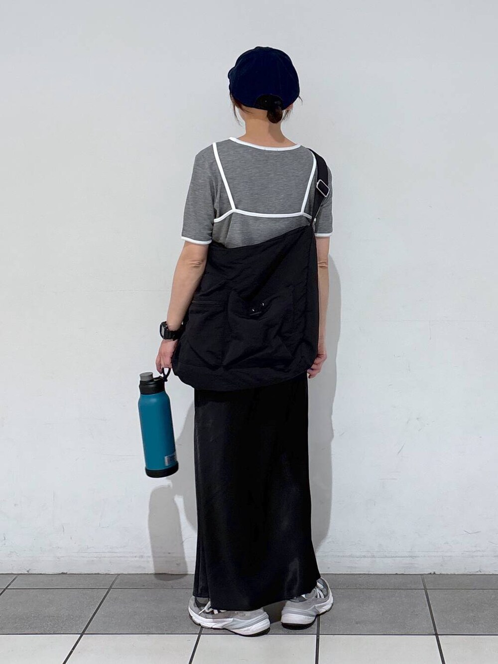 ブラック系のスカート、ブラック系のショルダーバッグ、グレー系のTシャツ/カットソーを着用したレディースの春コーディネートの6枚目の写真
