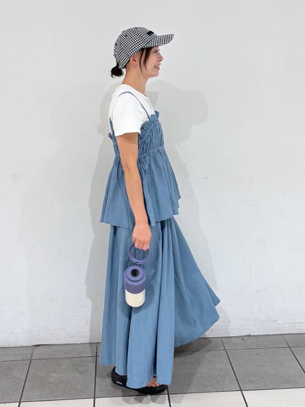 ブルー系のキャミソール、ホワイト系のTシャツ/カットソー、ブルー系のアウトドアグッズを着用したレディースの夏コーディネートの3枚目の写真