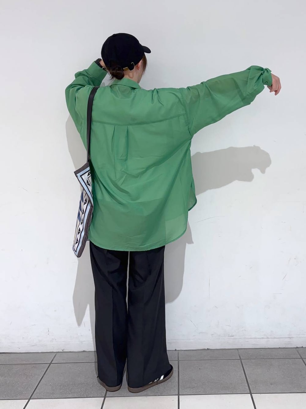 グリーン系のシャツ/ブラウス、ブラック系のその他パンツ、ベージュ系のトートバッグを着用したレディースの春コーディネートの5枚目の写真
