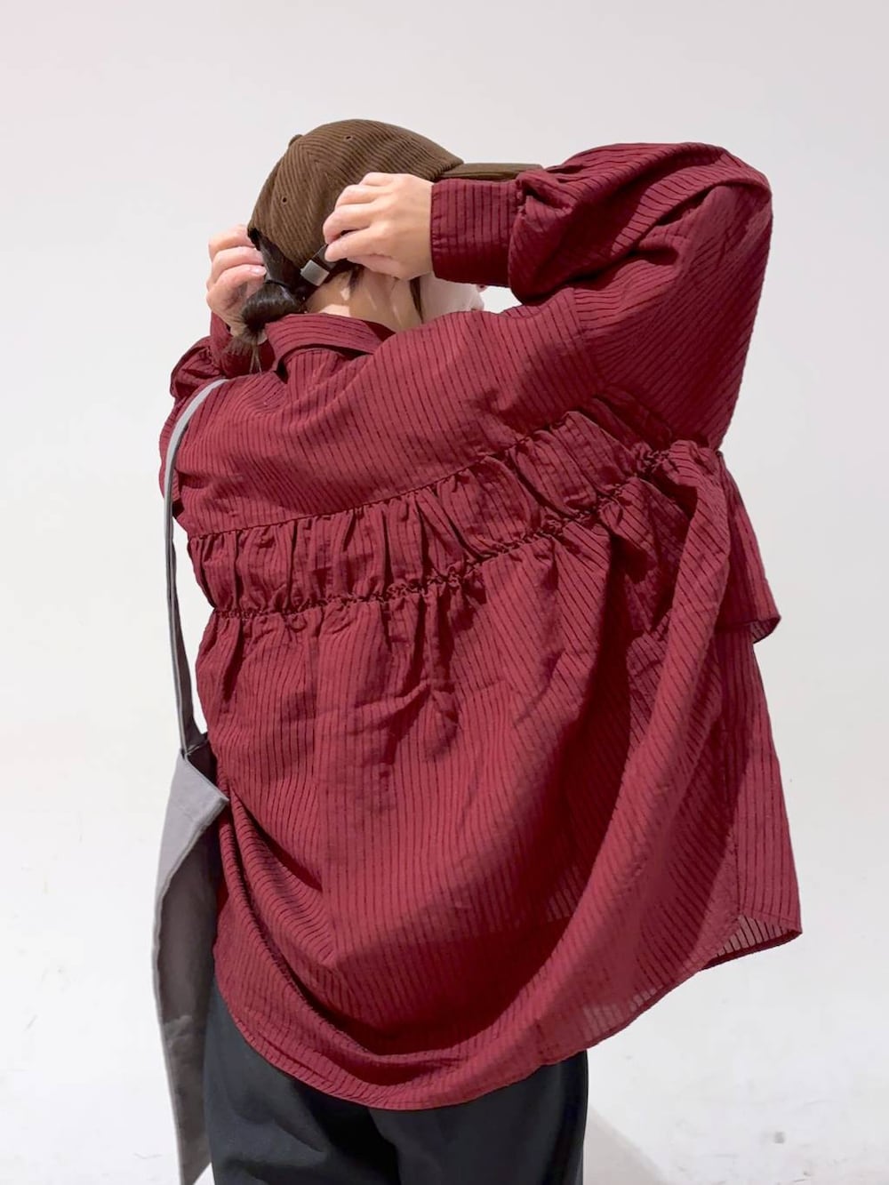 レッド系のシャツ/ブラウス、グレー系のトートバッグ、ブラウン系のキャップを着用したレディースの秋コーディネートの8枚目の写真