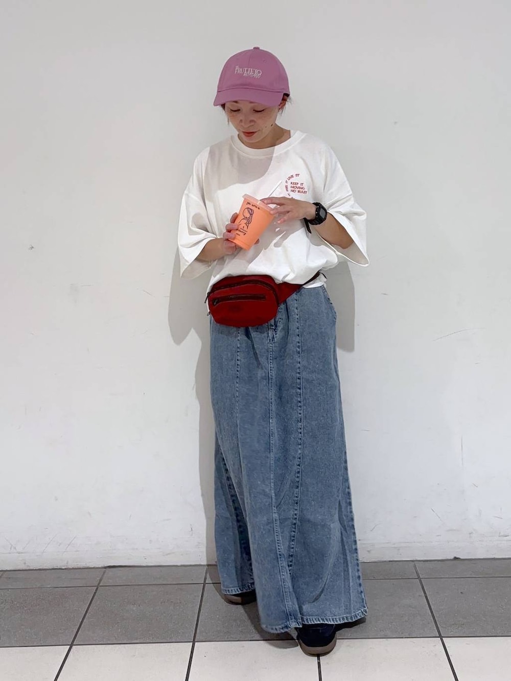 レッド系のボディバッグ/ウエストポーチ、ホワイト系のTシャツ/カットソー、ブルー系のデニムスカートを着用したレディースの夏コーディネートの7枚目の写真