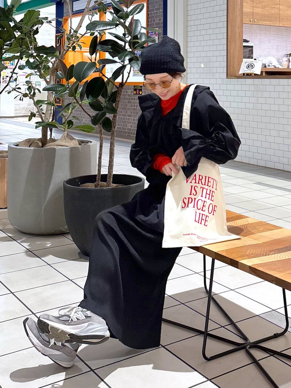 オレンジ系のTシャツ/カットソー、ホワイト系のトートバッグ、ブラック系のシャツ/ブラウスを着用したレディースの冬コーディネートの3枚目の写真