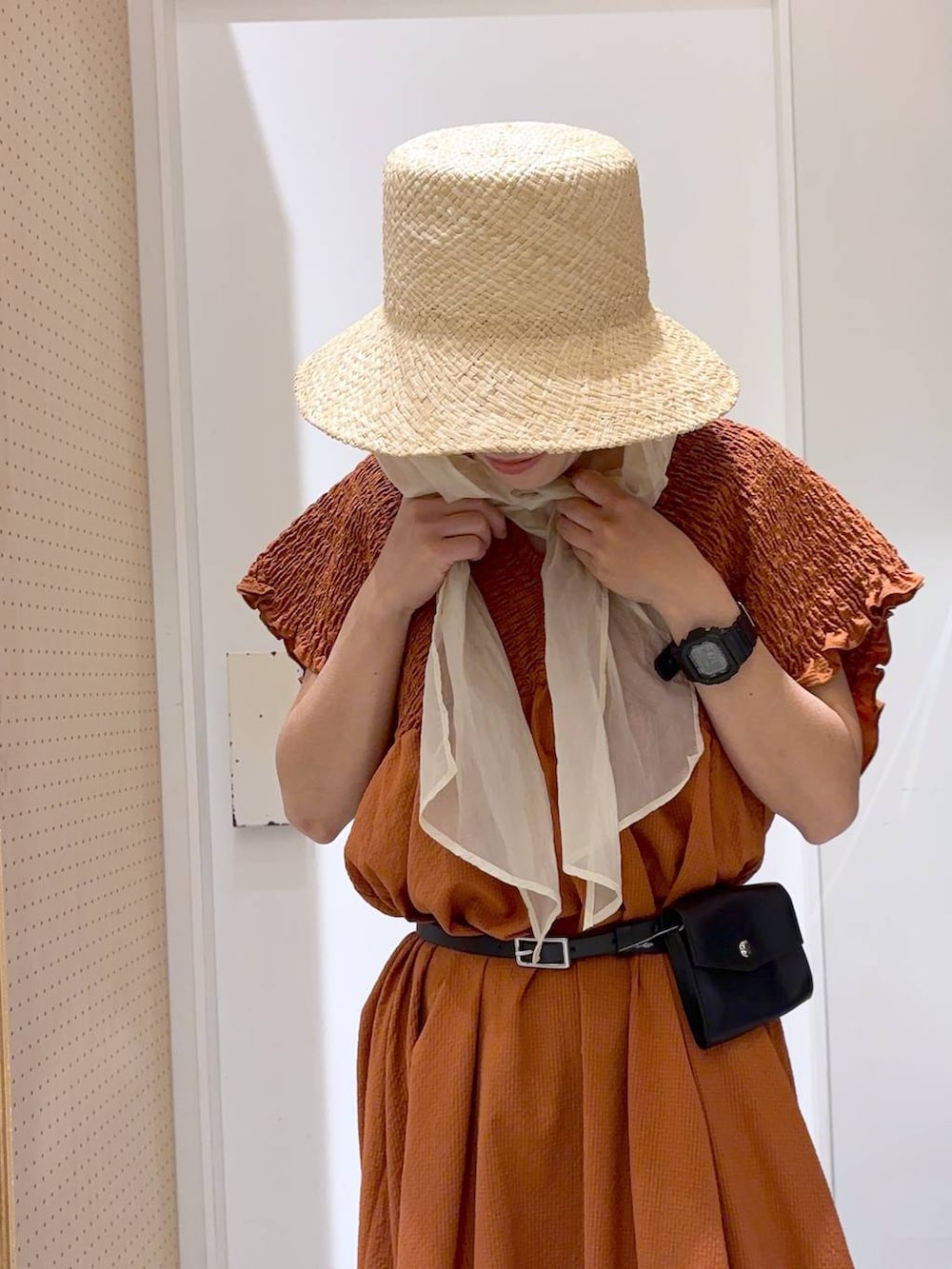 オレンジ系のワンピース、ブラック系のサンダル、ホワイト系のキャミソールを着用したレディースの夏コーディネートの6枚目の写真