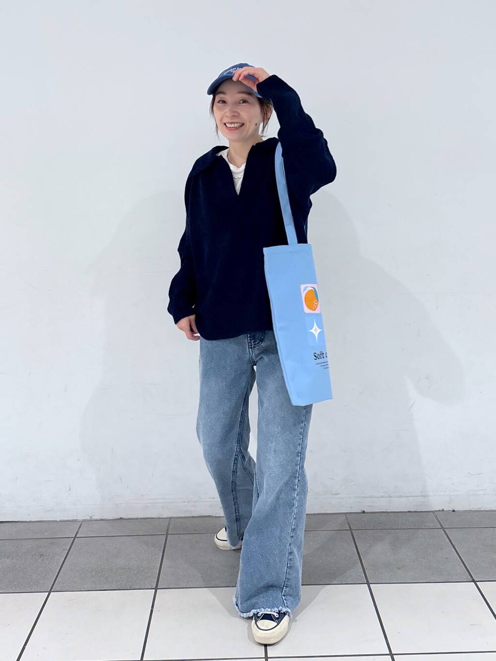 ブルー系のトートバッグ、ブルー系のニット/セーター、ブルー系のデニムパンツを着用したレディースの冬コーディネートの4枚目の写真