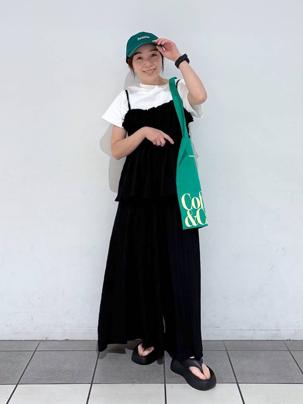 グリーン系のトートバッグ、ブラック系のサンダル、ブラック系のその他パンツを着用したレディースの春コーディネートの4枚目の写真