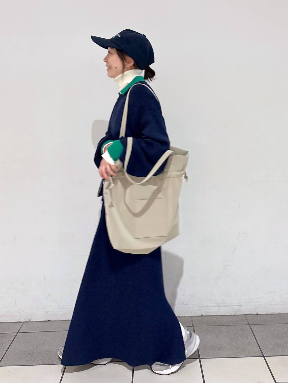 ベージュ系のトートバッグ、ベージュ系のニット/セーター、ブルー系のカーディガン/ボレロを着用したレディースの冬コーディネートの4枚目の写真