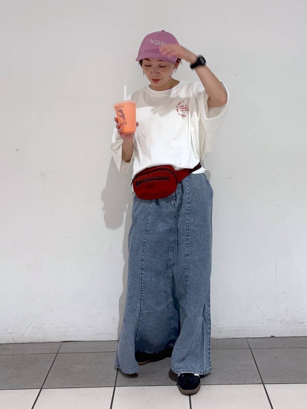 レッド系のボディバッグ/ウエストポーチ、ホワイト系のTシャツ/カットソー、ブルー系のデニムスカートを着用したレディースの夏コーディネートの3枚目の写真