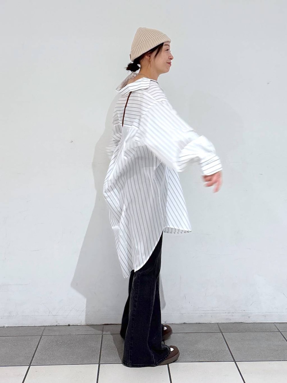 ホワイト系のスニーカー、ブラック系のデニムパンツ、ホワイト系のシャツ/ブラウスを着用したレディースの春コーディネートの3枚目の写真