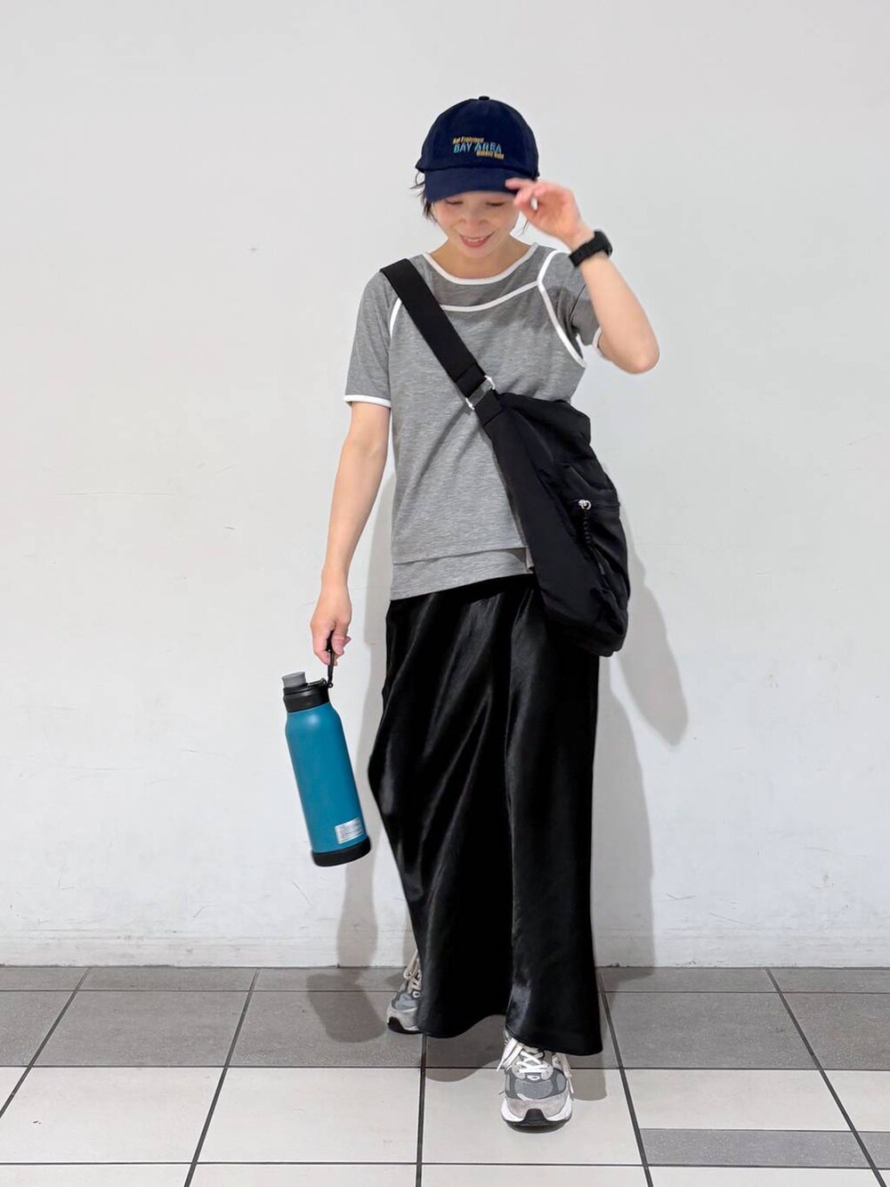 ブラック系のスカート、ブラック系のショルダーバッグ、グレー系のTシャツ/カットソーを着用したレディースの春コーディネートの3枚目の写真