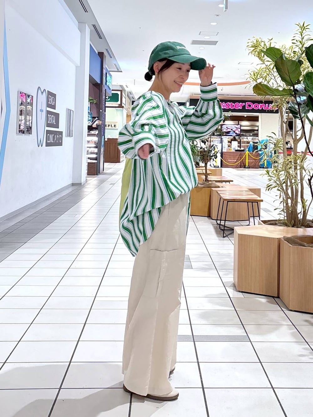 グリーン系のエコバッグ/サブバッグ、ホワイト系のスニーカー、グリーン系のシャツ/ブラウスを着用したレディースの春コーディネートの6枚目の写真