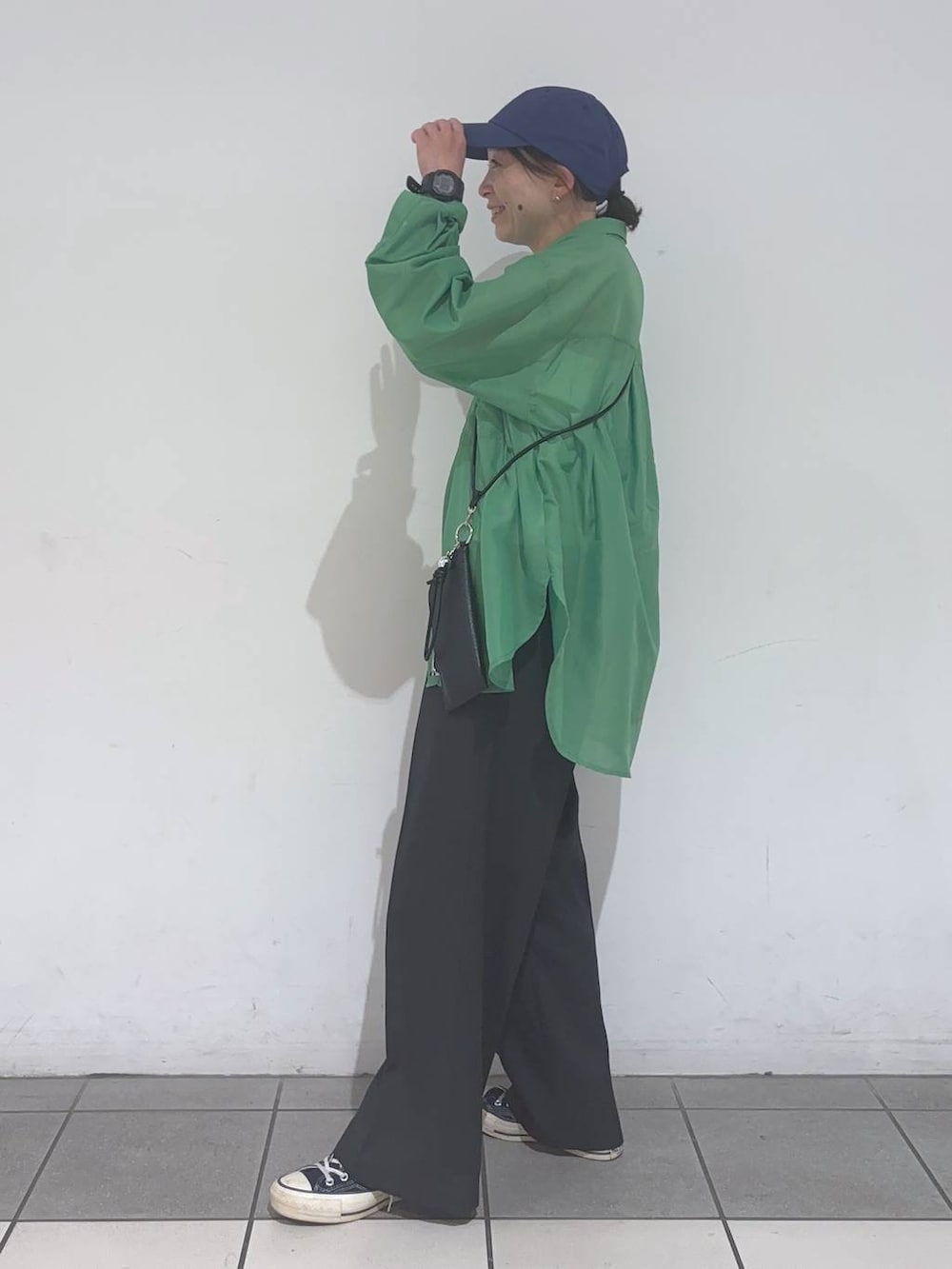 グリーン系のシャツ/ブラウス、ブラック系のその他パンツ、ブラック系のスマホグッズを着用したレディースの春コーディネートの5枚目の写真