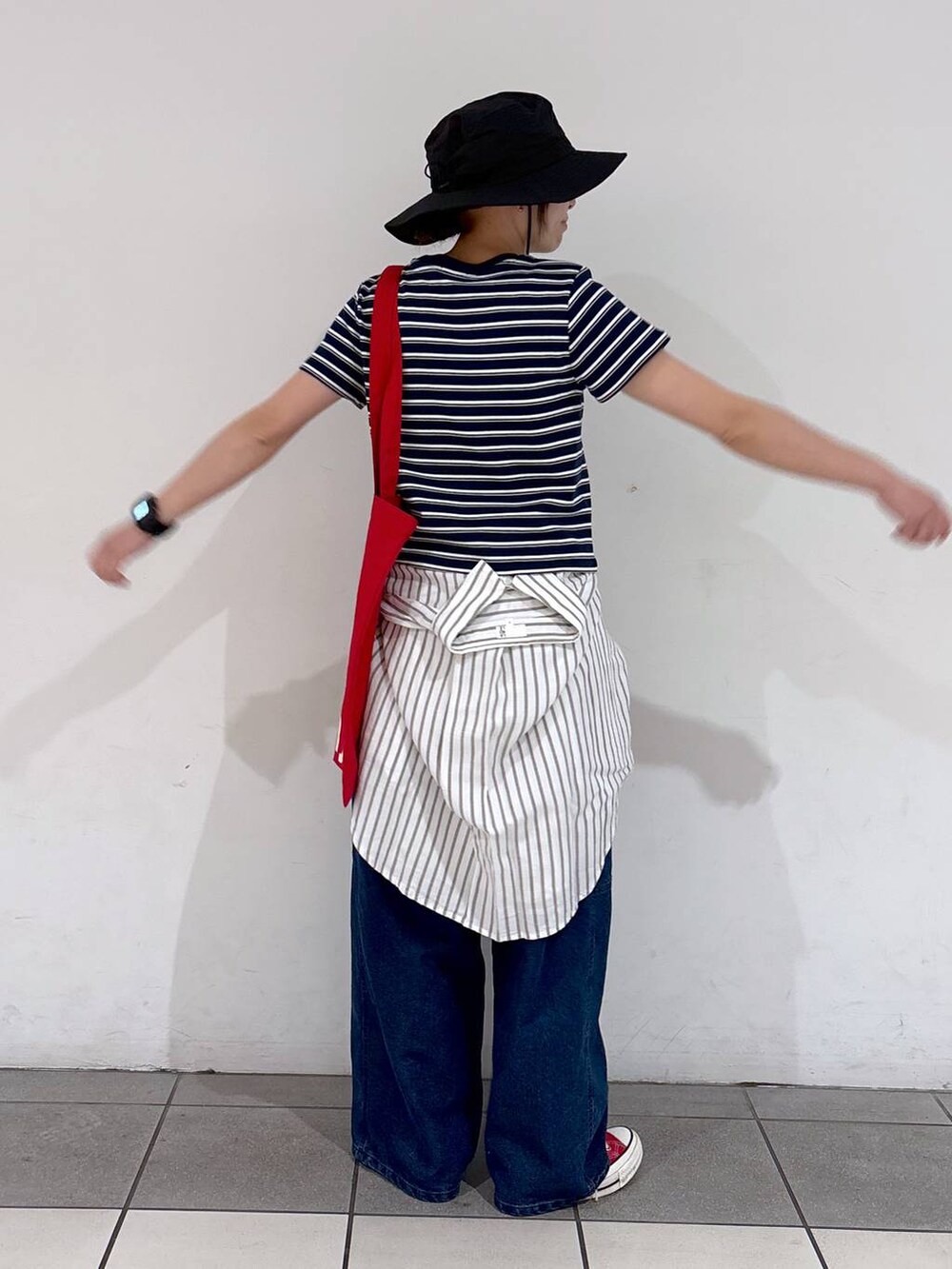 レッド系のトートバッグ、ブルー系のデニムパンツ、ホワイト系のシャツ/ブラウスを着用したレディースの春コーディネートの6枚目の写真
