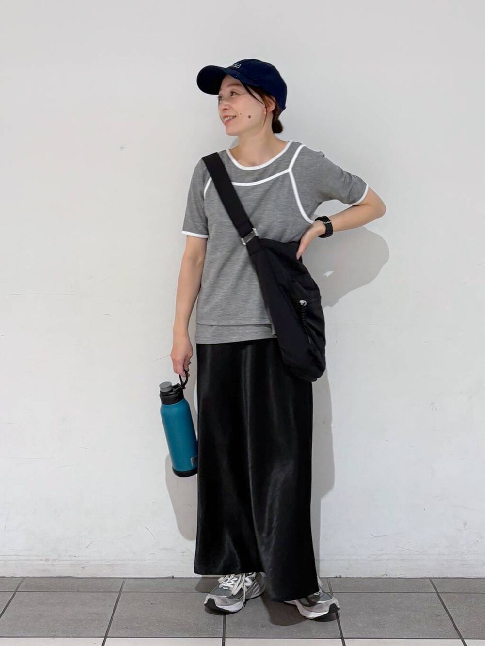 ブラック系のスカート、ブラック系のショルダーバッグ、グレー系のTシャツ/カットソーを着用したレディースの春コーディネートの4枚目の写真