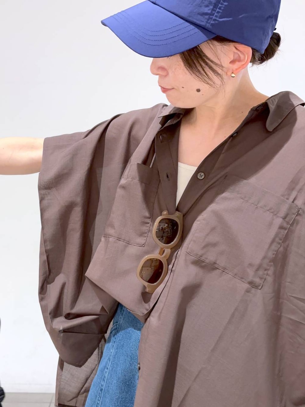 ブルー系のデニムパンツ、ホワイト系のキャミソール、ブラウン系のシャツ/ブラウスを着用したレディースの夏コーディネートの8枚目の写真