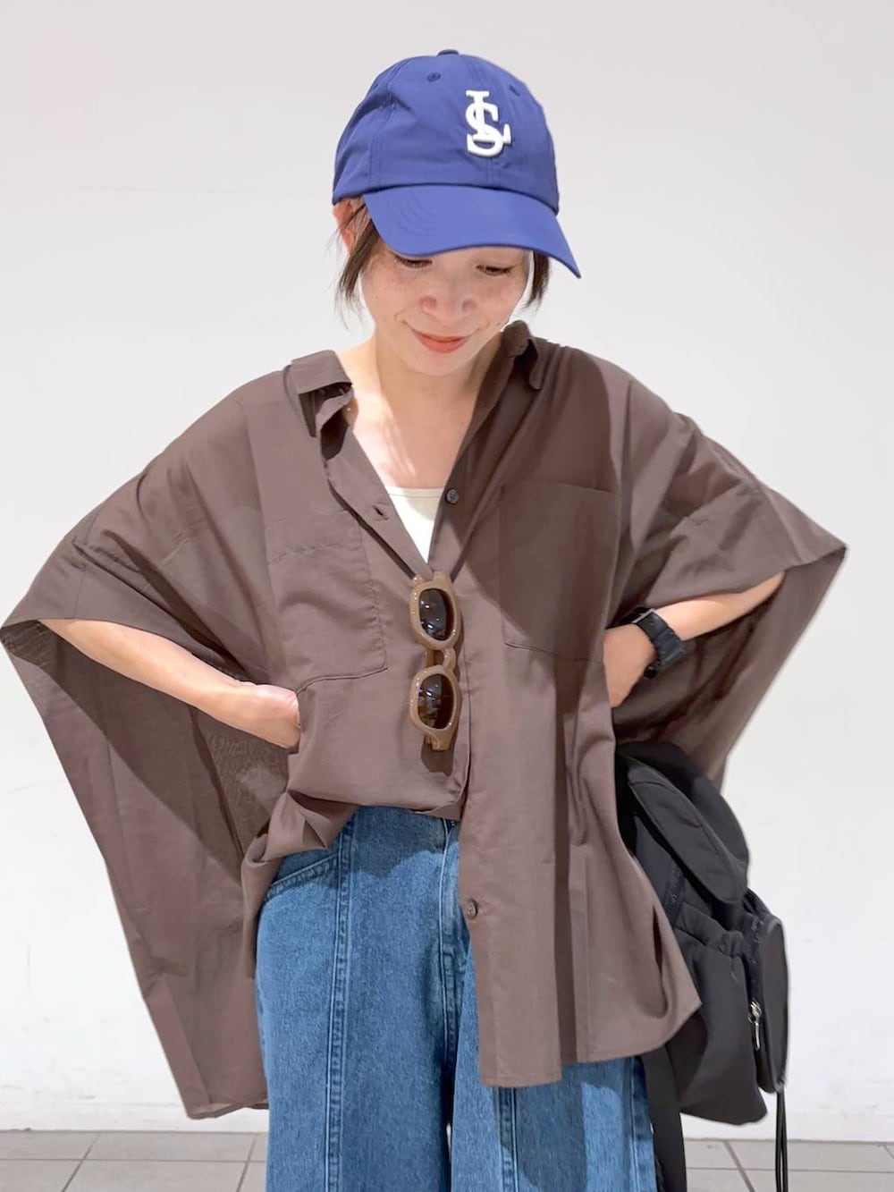 ブルー系のデニムパンツ、ホワイト系のキャミソール、ブラウン系のシャツ/ブラウスを着用したレディースの夏コーディネートの7枚目の写真