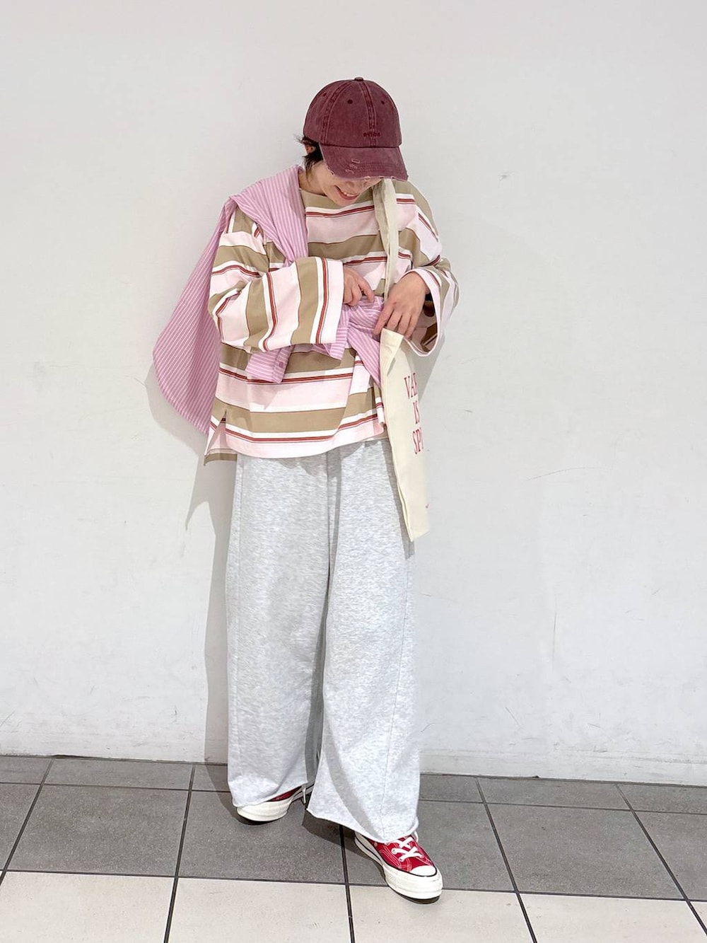 ホワイト系のトートバッグ、ピンク系のシャツ/ブラウス、グレー系のその他パンツを着用したレディースの冬コーディネートの2枚目の写真